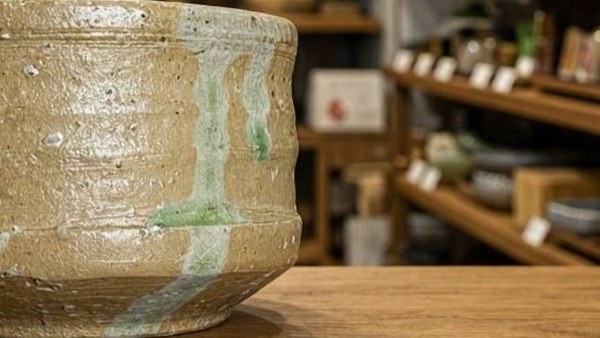 Green natural ash glaze running down one side of a Shigaraki vessel
