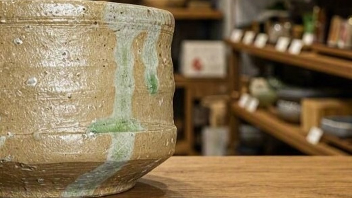 Green natural ash glaze running down one side of a Shigaraki vessel