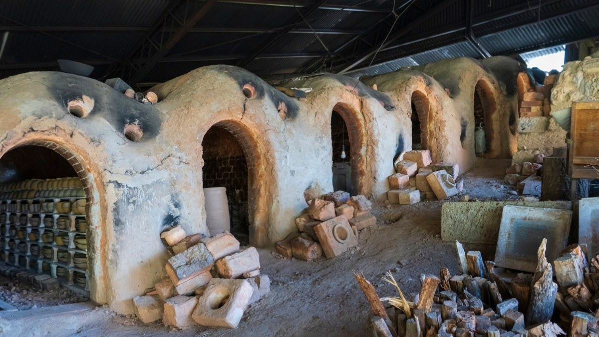 The mouths of a Shigaraki climbing kiln with red pine stacked beside them