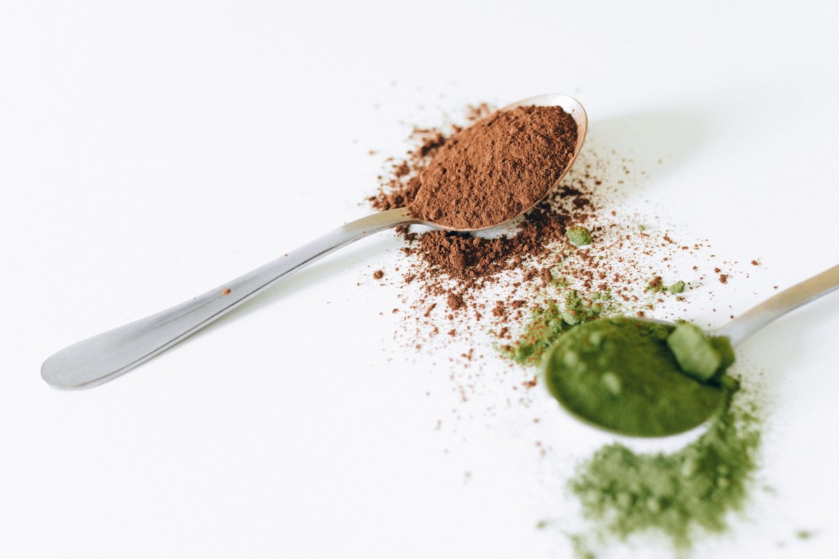 Green tea leaves and matcha powder side by side