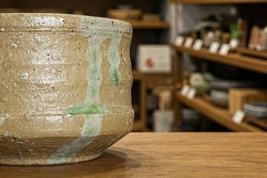 Green natural ash glaze running down one side of a Shigaraki vessel