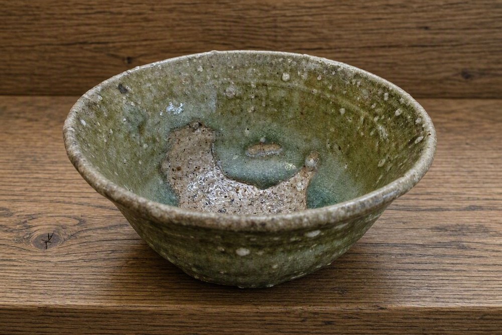 The inside of a Shigaraki bowl, its surface studded with white grains of feldspar